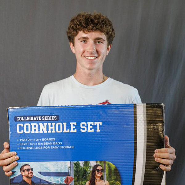Sam Malick holds a cornhole game set
