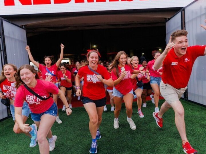Students emerge from the tunnel and onto the field in Memorial Stadium.